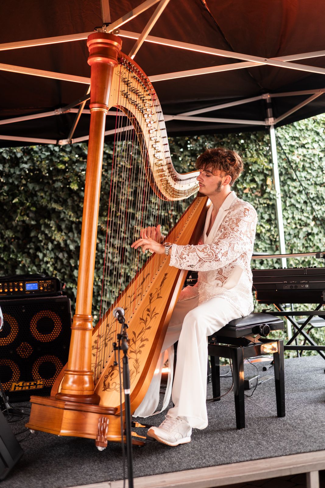 François Moriau jouant de la harpe en tenue blanche lors d'un événement d'entreprise en plein air